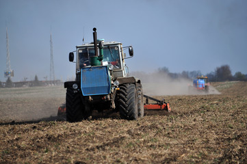Fototapeta premium Tractors prepare the area for planting sugar beets using strips for fine grinding ground