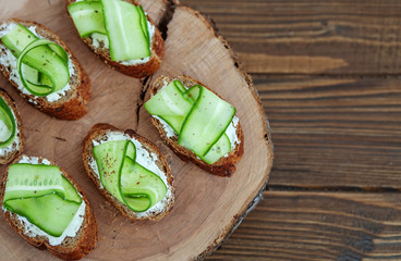 Sandwich with feta cheese and cucumber on a wooden board. Top view. The concept of food and vegetarianism.