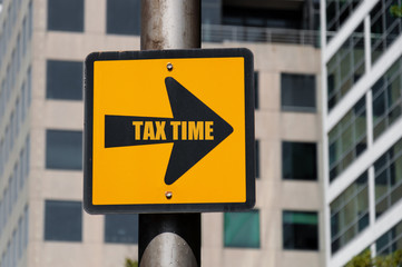 Directional sign with conceptual message TAX TIME