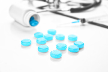 Cough drops spilling out of bottle on white background