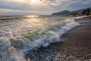 Scenic sunset on Black Sea coast in Sochi, Russia, with splashing waves. Beautiful summer landscape