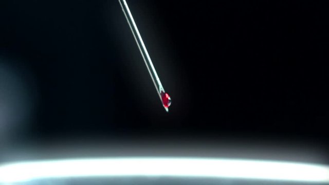 Close-up macro Drop of blood falling from syringe on black  background