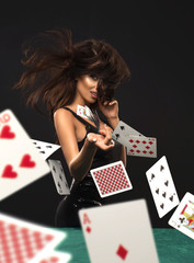 Sexy brunette woman with poker cards on black background