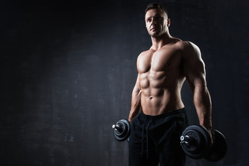 Fototapeta na wymiar Handsome muscular bodybuilder showing his muscles.