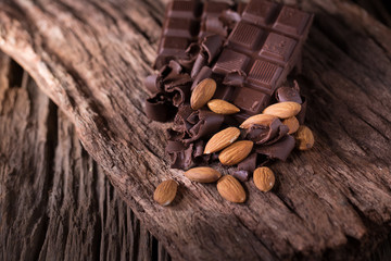 Chocolate bar pieces. large bar of chocolate and Almond nuts on wooden background