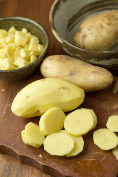 Potatoes and potato sliced on wooden table. Selective focus