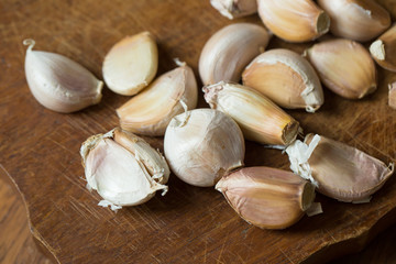 Garlic and garlic press on rustic wooden wooden background