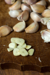 Fototapeta na wymiar Garlic and garlic press on rustic wooden wooden background
