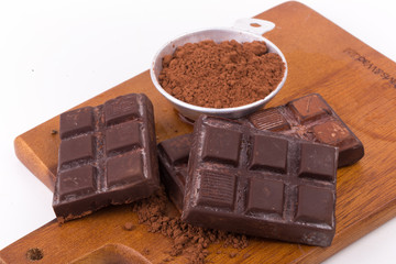 Chocolate chunks and cocoa powder. Chocolate bar pieces on white background