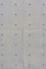 Grey concrete wall with holes. As background texture, copy space
