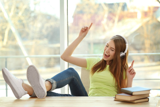 Beautiful young woman listening to music at home