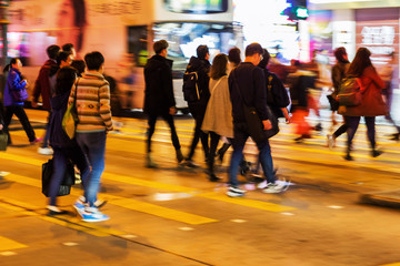 crowd of people crossing a street at night