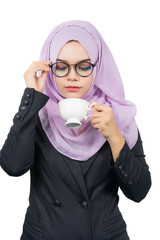 Beautiful modern Young Asian Muslim business woman holding a white coffee cup and look at coffee cup,isolated on white background.