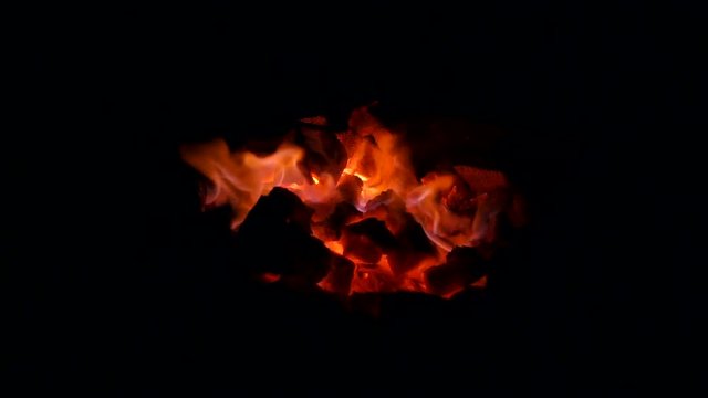 Smoldering coals in the fire close-up. Abstract background of burning coals.
