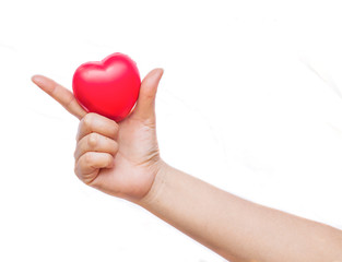 Fototapeta premium hand holding a red heart on white background