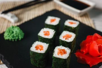 Appetizing, delicious and fresh sushi rolls set with smoked salmon served with ginger and wasabi on...