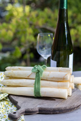 Spring food - fresh white big asparagus ready to cook on the table outside and garden view