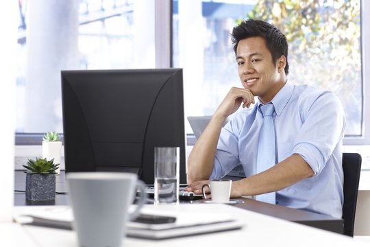 Happy businessman working with computer