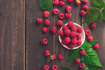 Red fresh raspberries on brown rustic wood background © Prostock-studio