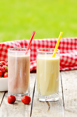 Banana and strawberry milkshake smoothie in the glass with straw