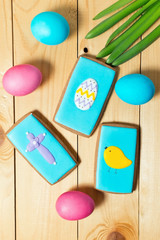 Easter homemade gingerbread cookies and eggs on wooden table