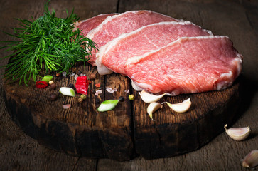 Raw meat steak with spices on a wooden board, selective focus
