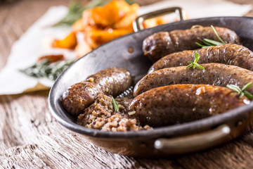 Sausages.Roasted pork sausage in a pan with potatoes and rosemary.