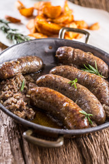 Sausages.Roasted pork sausage in a pan with potatoes and rosemary.