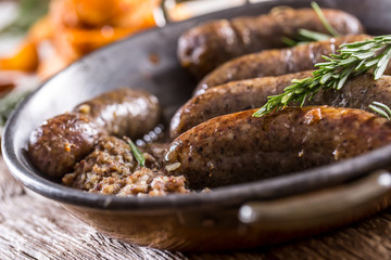 Sausages.Roasted pork sausage in a pan with potatoes and rosemary.