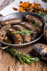 Sausages.Roasted pork sausage in a pan with potatoes and rosemary.