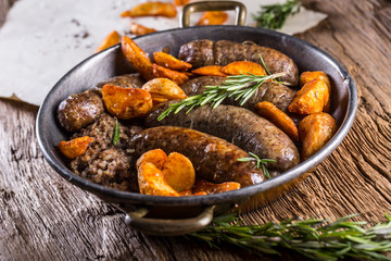 Sausages.Roasted pork sausage in a pan with potatoes and rosemary.
