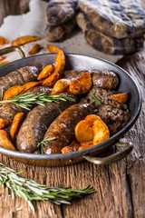 Sausages.Roasted pork sausage in a pan with potatoes and rosemary.
