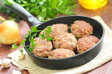 Cutlets with vegetables and herbs in pan
