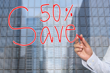 Hand of a businessman hand drawn a word of Save 50%.