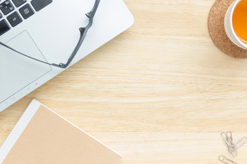 office desk with notebook keyboard and tea, top view with copy space