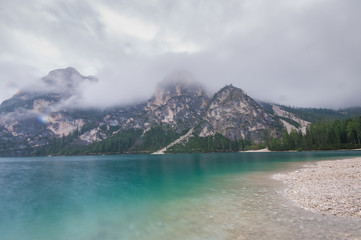 Cloudy and foggy morning on the alpine lake Lago di Braies, dolomites, italy