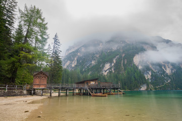 Fototapeta premium Cloudy and foggy morning on the alpine lake Lago di Braies, dolomites, italy