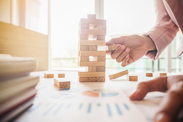 Hand of business man planning, risk and strategy in business.Businessman gambling placing wooden...