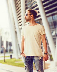 Young stylish handsome man posing in torn jeans