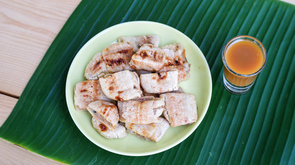 Grilled banana and sweet topping on banana leaves (Thai dessert).