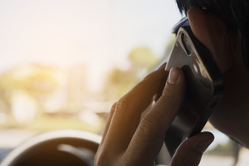 Close up of a man driving car dangerously while using mobile phone