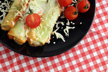 Baked cannelloni with minced meat and bechamel sauce on a plate. Italian cuisine