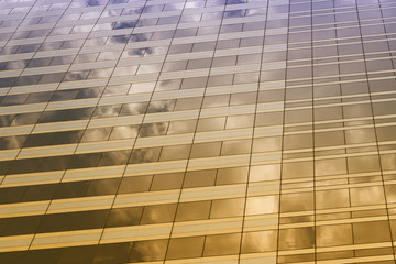 glass of the tall building with the glare of yellow and purple color.