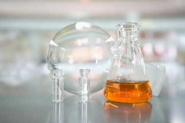 orange flask with vial and round bottle in science laboratory