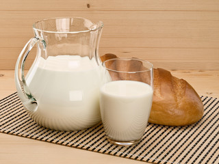 Glassware filled with milk and a white loaf long loaf
