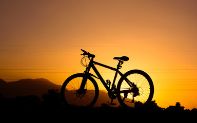 Fototapeta na wymiar silhouette of parked bicycle on warm tone with some copy space