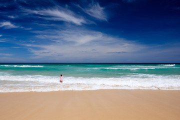 Cute girl play in the waves on sea.