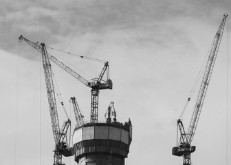 Construction of a house in the city. Construction process of a building, building a tower crane against the sky background.