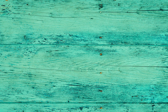 Wood plank fence in green and turquoise colors close up. Detailed background photo texture. Wooden wall abstract background.