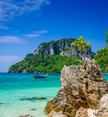 Tropischer See mit klarem türkisfarbenem Wasser, Felsen, Longtail-Boot und Insel. Typische thailändische Landschaft von Poda Island, West Railay Beach, Krabi, Thailand.